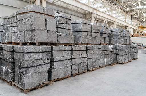 Pallets of compressed aluminum scrap bales stacked inside a warehouse